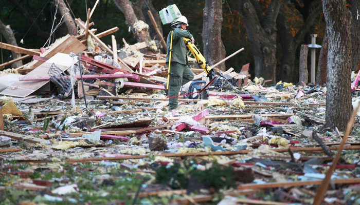 Wednesday morning, a ranger from the Department of Public Safety navigates through the debris after an explosion destroyed a two-story home in Victoria, Texas. Officials are investigating to find the cause of the blast Wednesday that killed 26-year-old Haley Singer, Victoria County Sheriff T. Michael O'Connor said. Firefighters found her 4-month-old daughter, Parker, alive in the debris. The child was being treated at a hospital in San Antonio, about 100 miles to the northwest. (AP Photo/The Victoria Advocate, Kathleen Duncan)