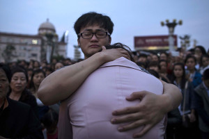 Relatives of passengers onboard the capsized cruise ship comfort each other during a candle light vigil in Jianli county  in southern China's Hubei province, Thursday.  Rescuers cut three holes into the overturned hull of a river cruise ship in unsuccessful attempts to find more survivors Thursday.  (Chinatopix via AP)